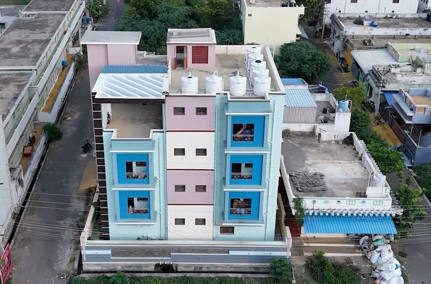 A three-storey residential block seen from above, balconies to every floor