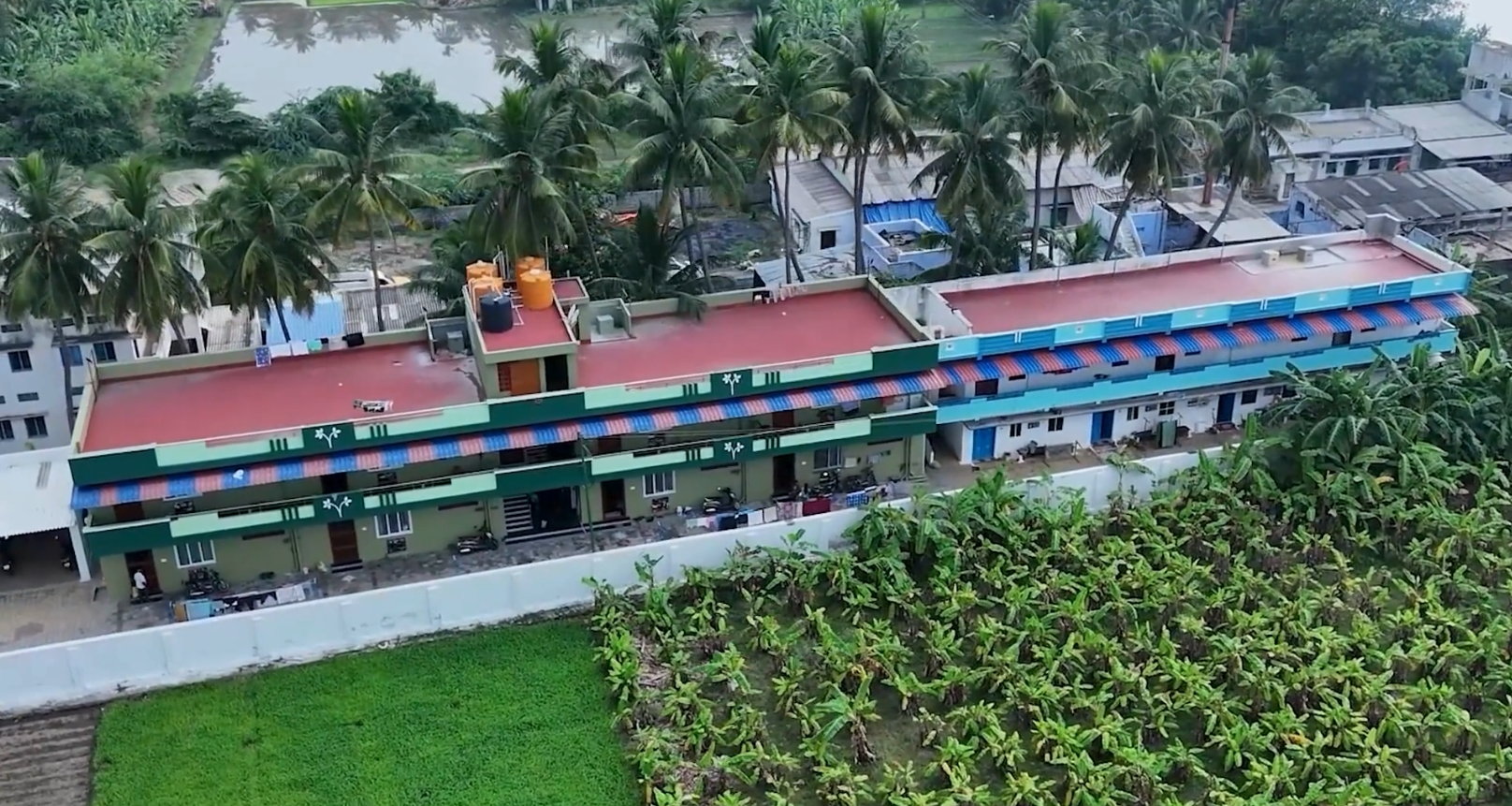 A long two-storey block of rental units beside open fields