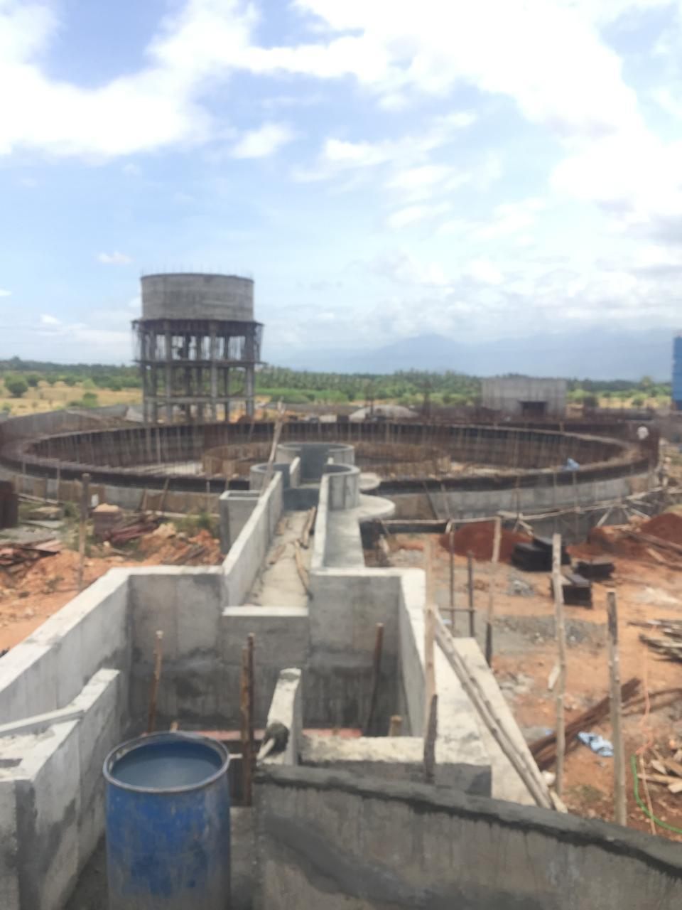 The treatment basins ringed with reinforcement, the overhead tank standing behind them