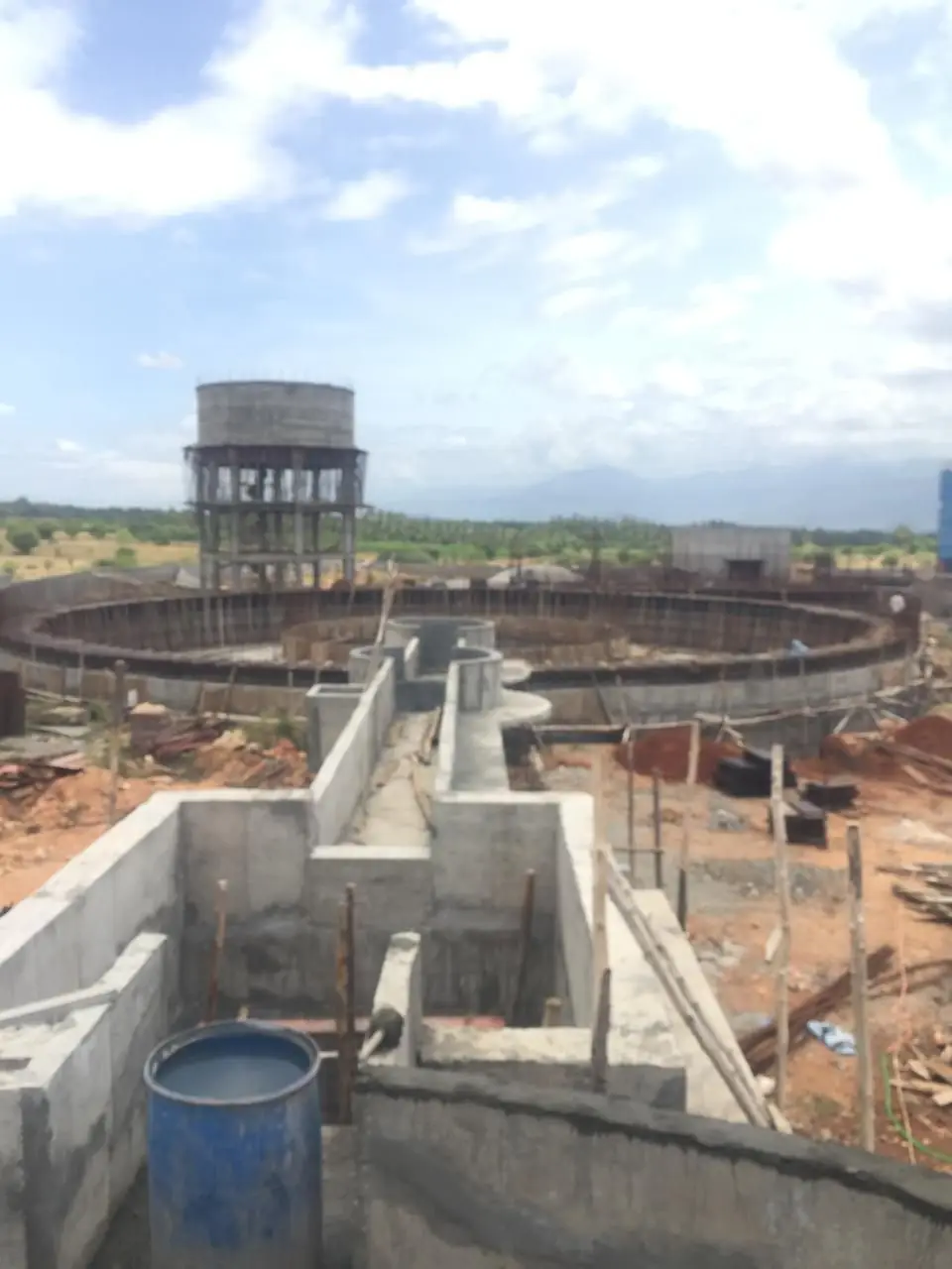 The treatment basins ringed with reinforcement, the overhead tank standing behind them